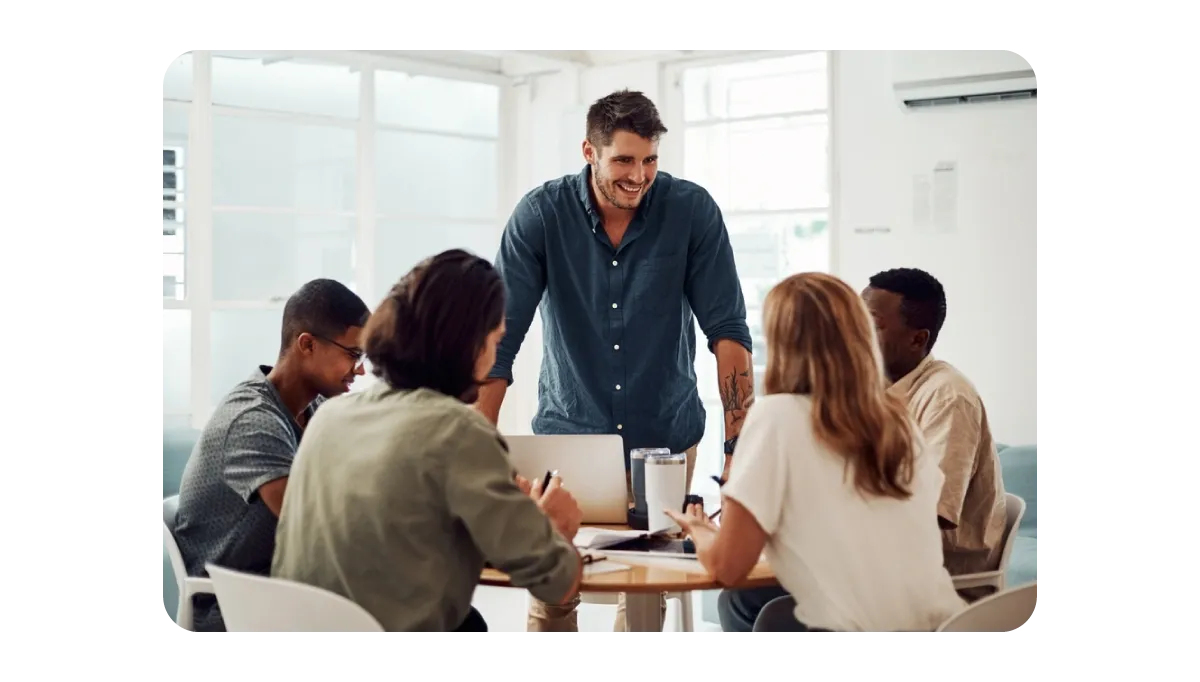 A group of professionals collaborating around a table in a modern office setting, depicting teamwork and effective communication.