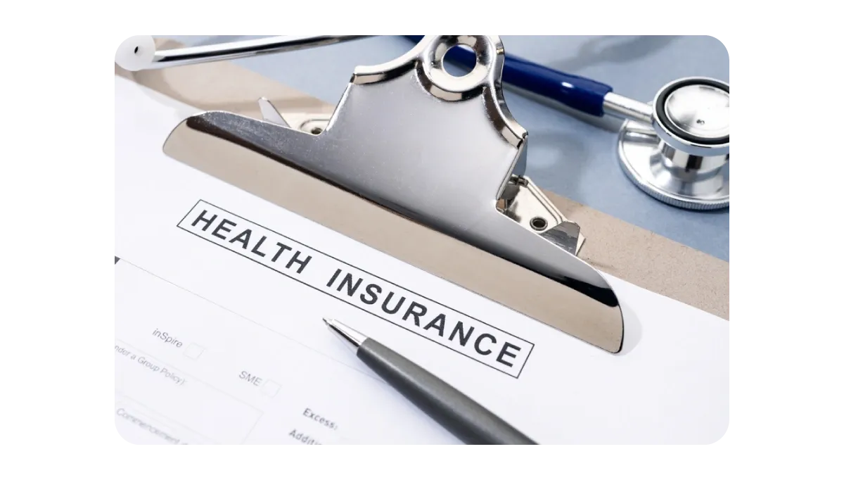 A health insurance form with a pen and stethoscope on a clipboard, representing healthcare documentation and plans.